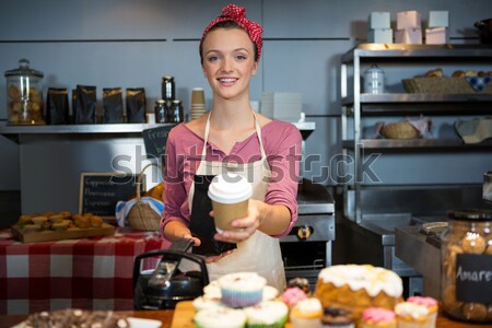Portrait of waitress holding cup of cold coffee Stock photo © wavebreak_media