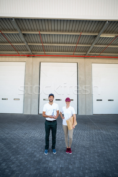 Portrait of delivery man and woman standing with clipboard and parcel Stock photo © wavebreak_media