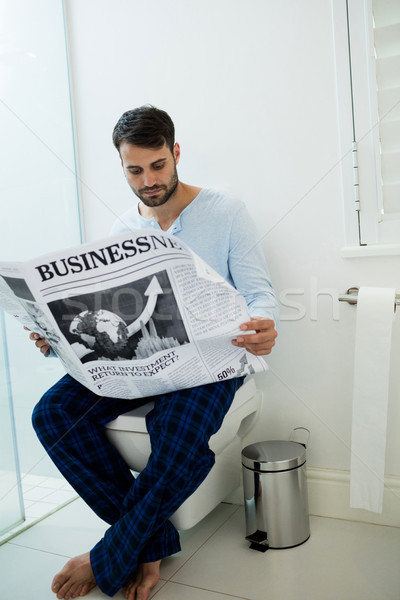 Man sitting on toilet seat reading a newspaper Stock photo © wavebreak_media