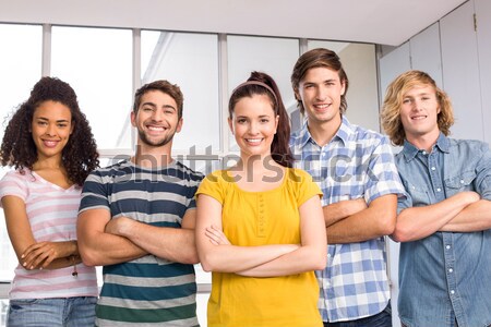 Happy college students with arms crossed against white tiling Stock photo © wavebreak_media