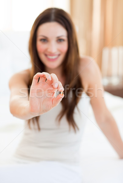 Mujer atractiva toma píldora sesión cama casa Foto stock © wavebreak_media