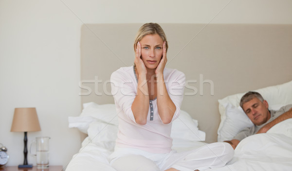 Woman having a headache while her husband is sleeping Stock photo © wavebreak_media