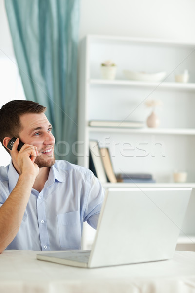 Smiling young businessman in his homeoffice using his cellphone Stock photo © wavebreak_media