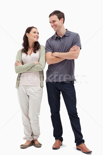 Couple with a complicit smile while crossing their arms against white background Stock photo © wavebreak_media