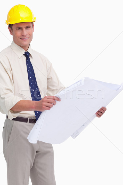 Smiling architect with helmet and plans against a white background Stock photo © wavebreak_media