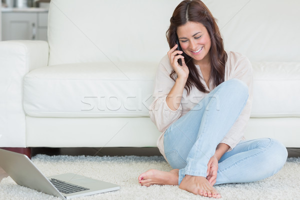 Mujer llamando portátil alfombra casa teléfono Foto stock © wavebreak_media