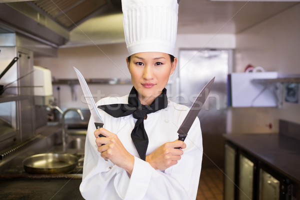 Confident female cook holding knives in kitchen Stock photo © wavebreak_media