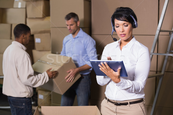 Stock photo: Pretty warehouse manager using tablet during busy period