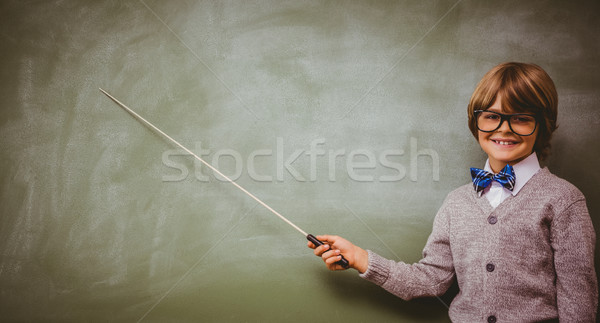Boy holding stick in front of blackboard Stock photo © wavebreak_media