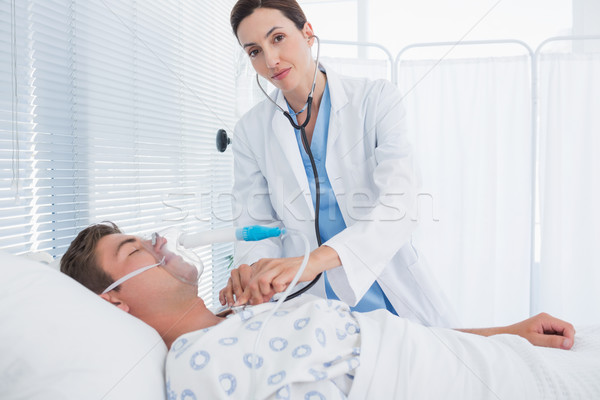 Smiling doctor auscultating her patients chest Stock photo © wavebreak_media