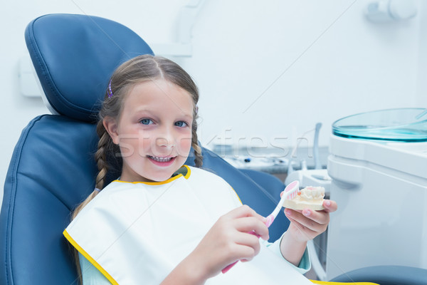 Stock photo: Little girl learning how to brush teeth