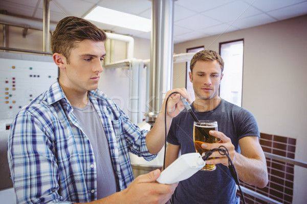 Two casual men testing beer in the beaker Stock photo © wavebreak_media