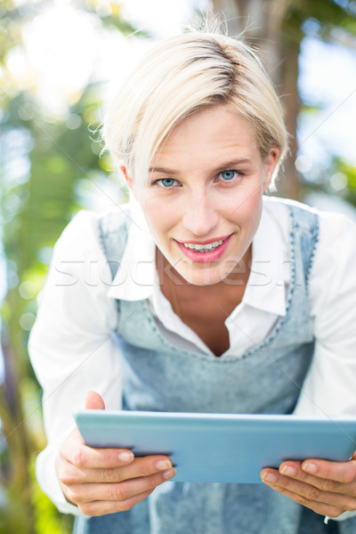 Pretty blonde woman using her tablet Stock photo © wavebreak_media