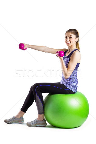 Fit woman lifting dumbbell sitting on ball Stock photo © wavebreak_media