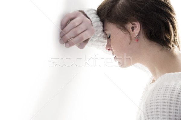 Sad pretty brunette leaning against wall Stock photo © wavebreak_media