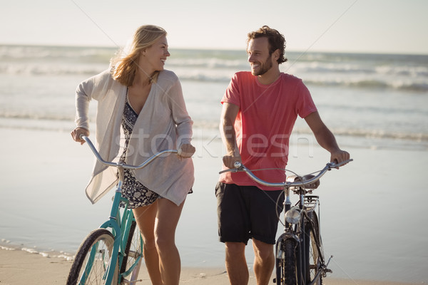 Stock photo: Happy couple with bicycles walking at beach