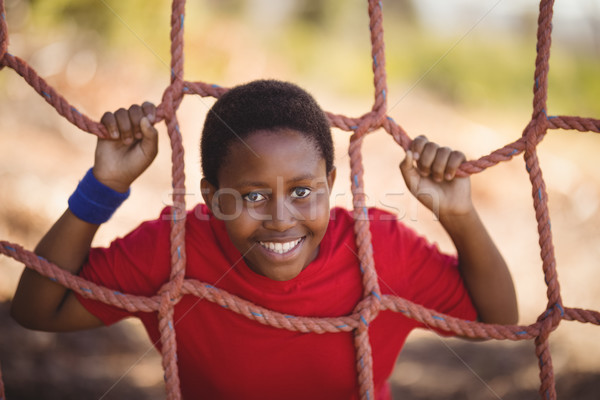 Portrait of happy boy leaning on net during obstacle course Stock photo © wavebreak_media