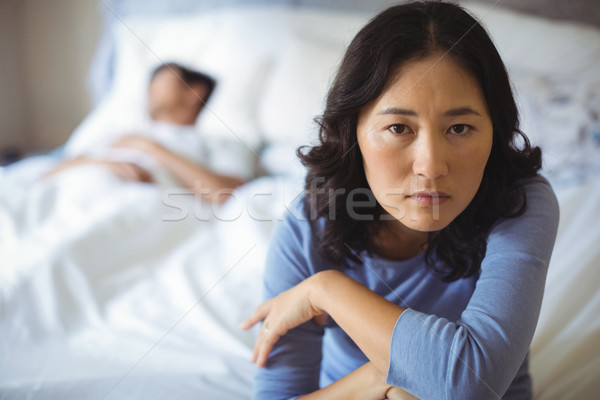 Bouleversé femme séance lit chambre maison [[stock_photo]] © wavebreak_media