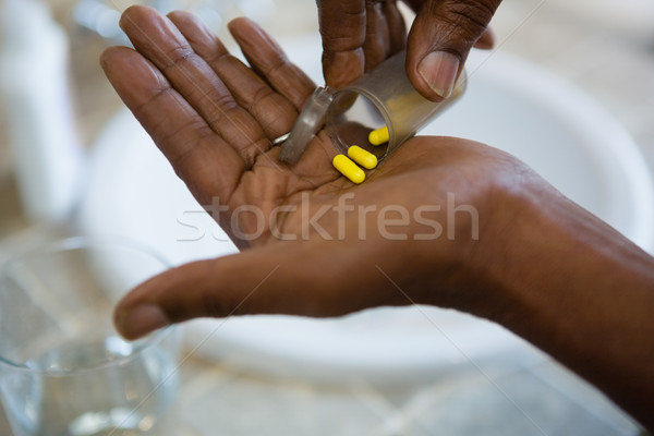 Cropped hands of person holding medicines in bathroom Stock photo © wavebreak_media