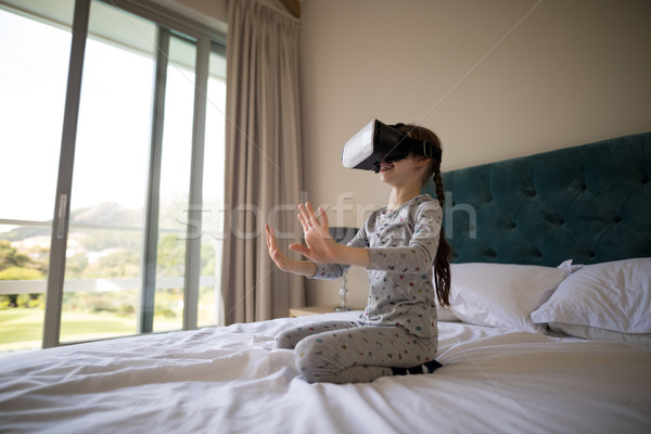 Girl using virtual reality headset on bed Stock photo © wavebreak_media