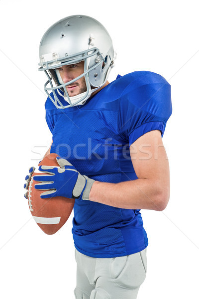 American football player holding ball while looking away Stock photo © wavebreak_media