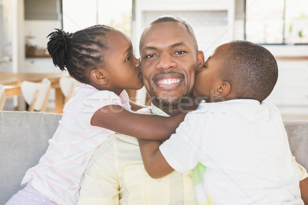 Happy father is kissed by his two children Stock photo © wavebreak_media