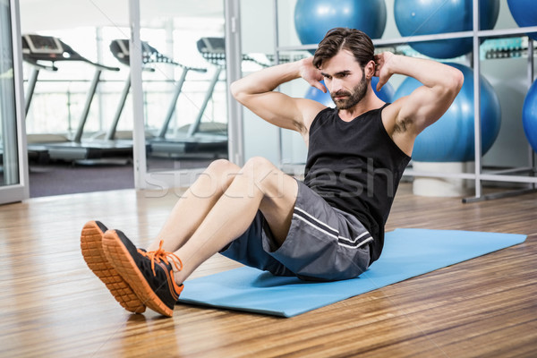 Serious man doing abdominal on the mat Stock photo © wavebreak_media