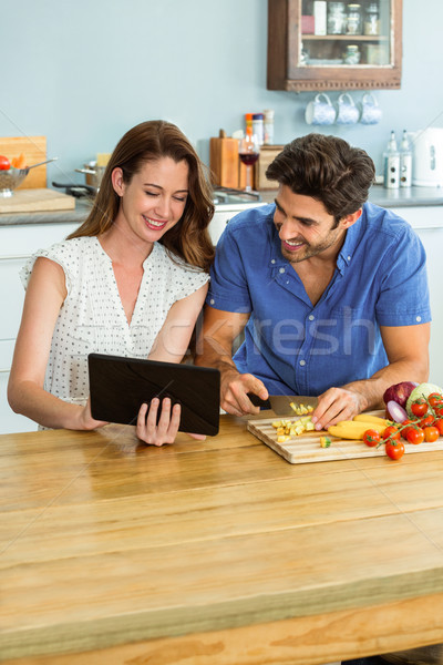 Woman using digital tablet and man chopping vegetables Stock photo © wavebreak_media