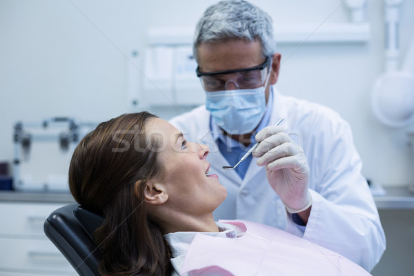 Dentist examining a young patient with tools Stock photo © wavebreak_media