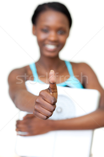 Stock photo: Cheerful fitness woman with thumb up holding a weight scale