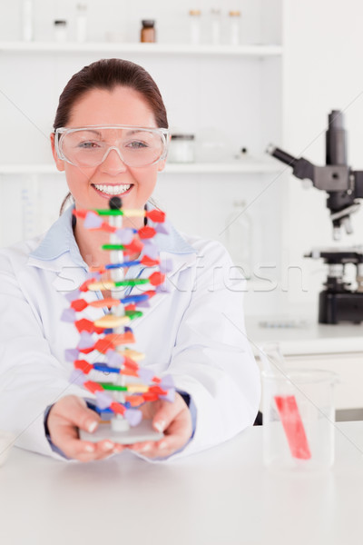 Portrait of a smiling scientist showing the dna double helix model Stock photo © wavebreak_media