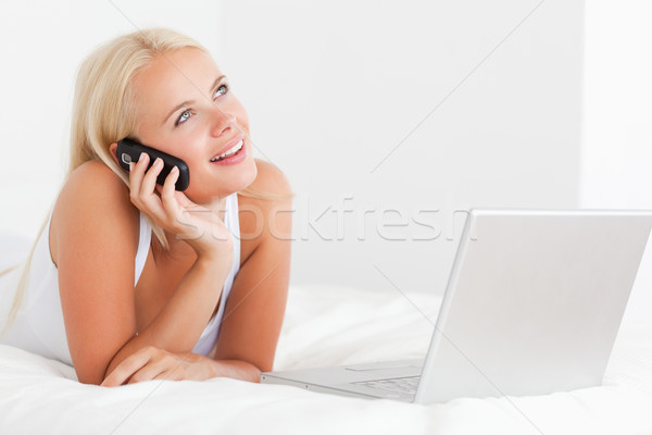 женщину телефон ноутбука спальня компьютер улыбка интернет Сток-фото © wavebreak_media