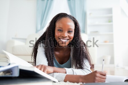 Glimlachende vrouw tapijt woonkamer huiswerk werk pen Stockfoto © wavebreak_media