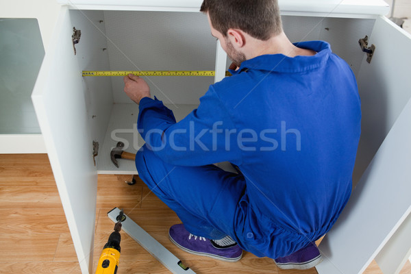 Young repair man measuring something in a kitchen Stock photo © wavebreak_media