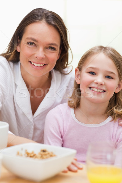 Portrait of a lovely mother and her daughter having breakfast in a kitchen Stock photo © wavebreak_media