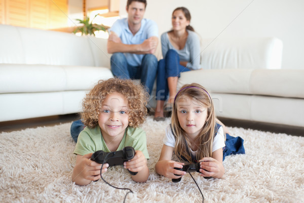 Children playing video games while their parents are watching in their living room Stock photo © wavebreak_media