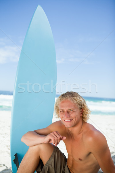 Uśmiechnięty człowiek posiedzenia plaży ramię nogi Zdjęcia stock © wavebreak_media