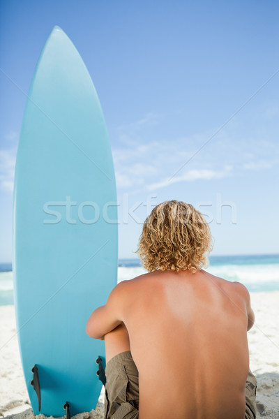 Blonde man sitting on the beach with his arms around his legs Stock photo © wavebreak_media