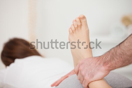 Woman lying forward while a physio manipulates her foot in a room Stock photo © wavebreak_media