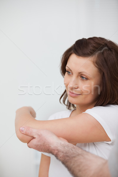 Smiling woman being stretched by a man in against grey background Stock photo © wavebreak_media