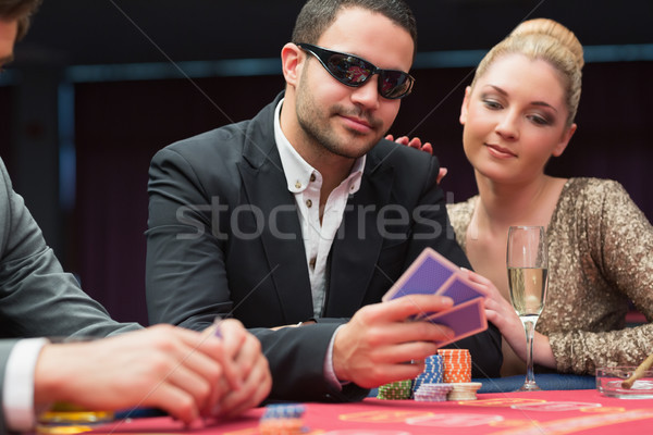 Man in sunglasses showing hand to woman beside him at poker game in casino Stock photo © wavebreak_media