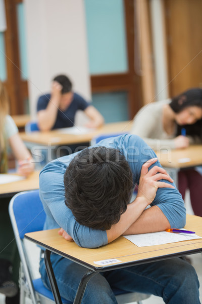 Boy sleeping at desk during exam in exam hall in college Stock photo © wavebreak_media
