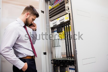 Man fixing server wires and talking on phone Stock photo © wavebreak_media