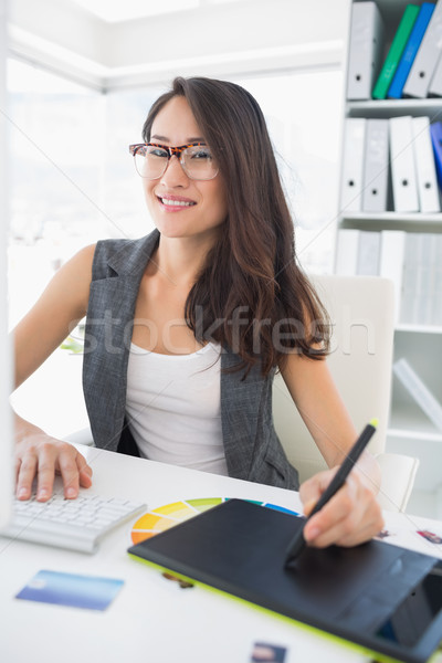 Smiling casual female photo editor using graphics tablet Stock photo © wavebreak_media