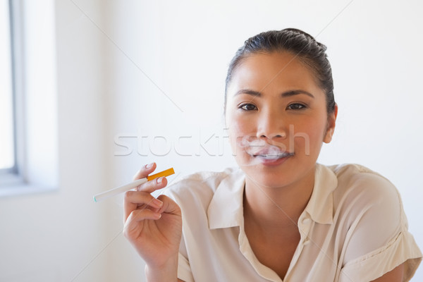 Femme d'affaires fumer électronique cigarette bureau [[stock_photo]] © wavebreak_media