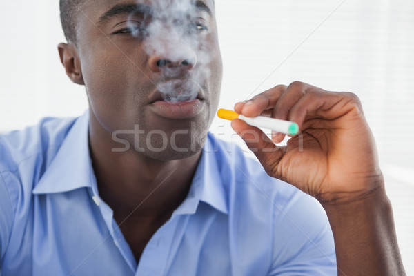 Businessman smoking an electronic cigarette Stock photo © wavebreak_media