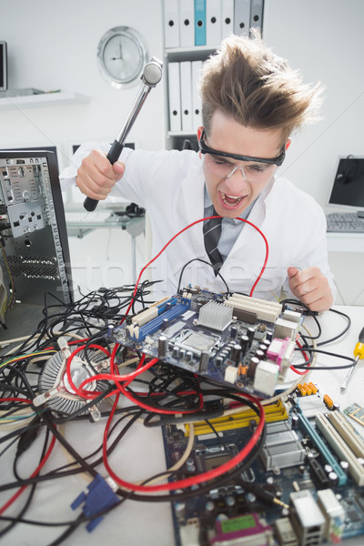 Angry computer engineer holding hammer over console Stock photo © wavebreak_media