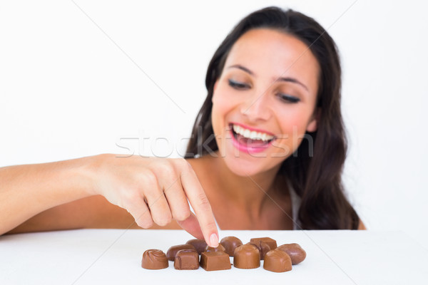 Pretty brunette picking out chocolate Stock photo © wavebreak_media