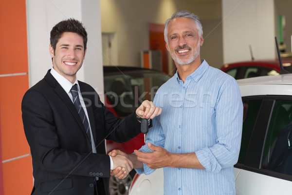 Businessman giving car key while shaking a customer hand Stock photo © wavebreak_media