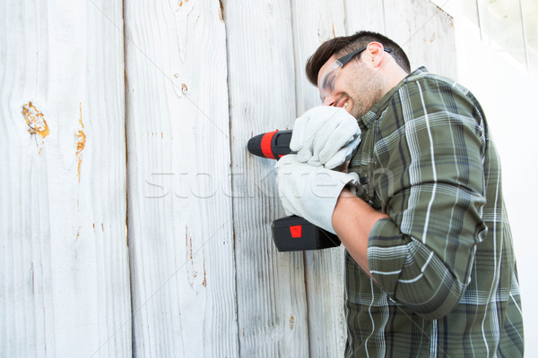 Worker using hand drill on wooden cabin Stock photo © wavebreak_media
